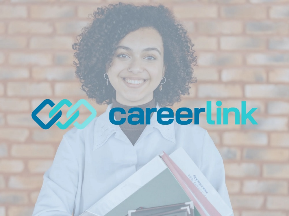 A person holding books and smilingAI-generated content may be incorrect.